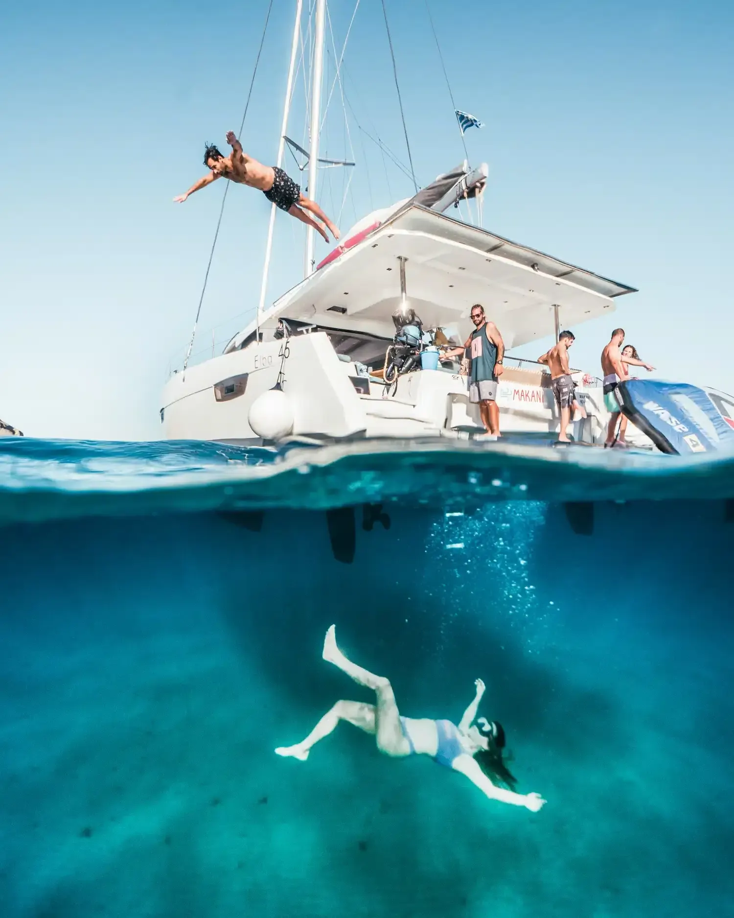 Makani catamaran anchored above turquoise water in the Cyclades.